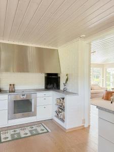 a kitchen with white cabinets and a stove top oven at Villa With Architect-Designed Garden In Alsvik in Sørvåg