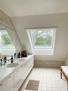a bathroom with two sinks and a window at Villa With Architect-Designed Garden In Alsvik in Sørvåg