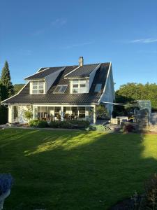a house with a metal roof on a lawn at Villa With Architect-Designed Garden In Alsvik in Sørvåg
