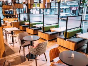 een restaurant met tafels en stoelen in een kamer bij ibis Belfast City Centre in Belfast