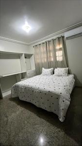 a bedroom with a white bed with pillows and a window at Família Macapá in Macapá +23 photos