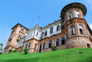 ein großes Backsteingebäude auf einem grünen Hügel in der Unterkunft Ipoh Anderson Condo - 2BR in Ipoh