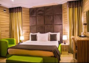 una camera con un grande letto e una sedia verde di Apartment 550 Suites ad Abuja