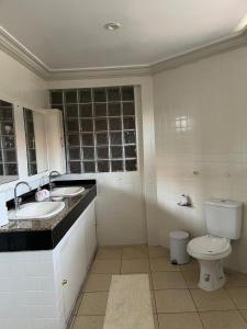 a bathroom with two sinks and a toilet in it at Família Macapá in Macapá