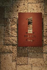 a sign for a hotel on a brick wall at 1 Hotel Tokyo in Tokyo +29 photos