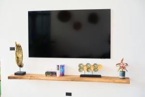 a flat screen tv on a wall with a shelf at Sunset 3 Bedroom Sea View Villa with Infinity Pool in Chalok Ban Kao in Hinkong