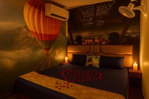 Urban homestay volcastay في Zirakpur: غرفة نوم مع سرير مع بالون وشموع