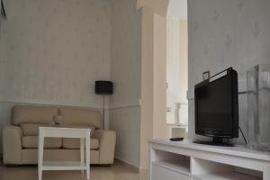 ein Wohnzimmer mit einem Sofa und einem TV in der Unterkunft Convento Tarifa in Tarifa