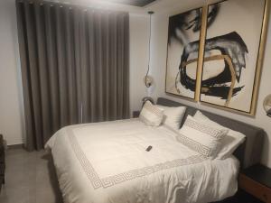 a bedroom with a bed with white sheets and pillows at beautiful house near the consulate in Manuel F. Martínez