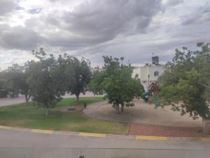 a view of a park with trees and a building at beautiful house near the consulate in Manuel F. Martínez