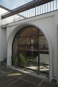 un arco con una planta bajo un balcón en Verandah Glamping Villa Mangli, en Prampelan
