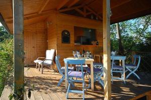 un patio con mesas azules y sillas en una cabaña en Casa Verde, en San Michele in Teverina