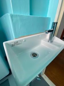 ein weißes Waschbecken mit einem Wasserhahn in einem Badezimmer in der Unterkunft KAMEYA HOUSE ENOSHIMA - Vacation STAY 01325v in Fujisawa + 23 Fotos