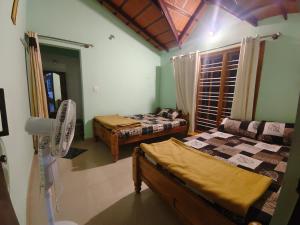 a room with two beds and a fan in it at Himagni Homestay - Entire Villa in Sakleshpur