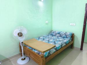 a small bedroom with a bed with a fan at Himagni Homestay - Entire Villa in Sakleshpur +46 photos