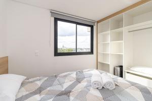ein Schlafzimmer mit einem Bett mit Handtüchern darauf in der Unterkunft Edifício Smart Home | Gonzaga Stays in Curitiba