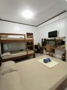 a bedroom with two bunk beds and a desk at Villa Monica Hotel in Balatero