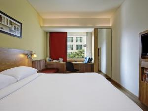 a bedroom with a large white bed and a desk at ibis Bengaluru Outer Ring Road in Bengaluru +70 photos