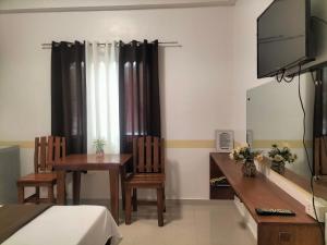 a room with a table and chairs and a mirror at Villa Monica Hotel in Balatero