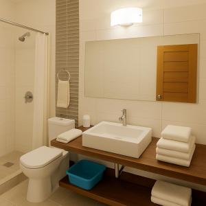 ein Badezimmer mit Waschbecken, Toilette und Spiegel in der Unterkunft Beach Home Organos Piura Family Vacations in Los Órganos