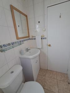 a white bathroom with a toilet and a sink at Casa Hospedaje Costanera in Puerto Natales +31 photos