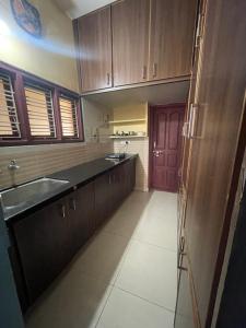 a kitchen with wooden cabinets and a sink at Sri padha vallabha serenity homestay in Pithāpuram +17 photos
