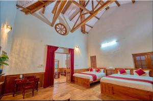 乌提Shivvs Heritage Resort Ooty的一间卧室配有两张床和一张桌子
