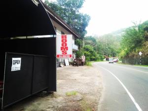 un bâtiment avec un panneau sur le côté d'une route dans l'établissement River side resort, à Balangoda