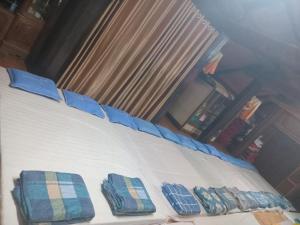 a bed with two blue pillows on top of it at An' Home Mai Chau in Mai Chau