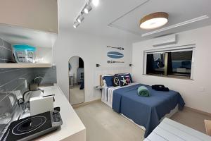 a small bedroom with two beds and a kitchen at Moderno com piscina e perto da praia in Rio de Janeiro