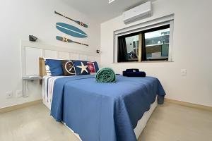 a bedroom with a blue bed and a window at Moderno com piscina e perto da praia in Rio de Janeiro +224 photos
