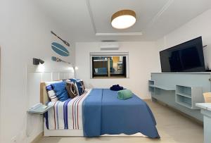 a bedroom with a bed and a flat screen tv at Moderno com piscina e perto da praia in Rio de Janeiro