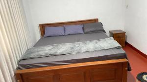 a bed in a bedroom with a wooden bed frame at White Cozy Family Bungalow in Badulla