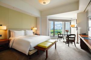 a bedroom with a large bed and a desk and a table at Palace Hotel Tokyo in Tokyo