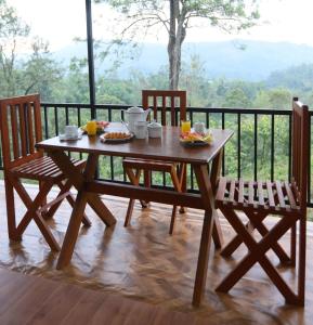 a wooden table and two chairs with food on it at Ella Ninestars Lodge in Ella