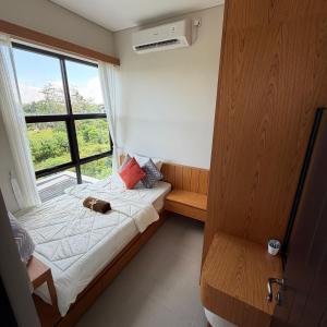 un cane che giace su un letto in una stanza con finestra di Elegant 3 bedroom villa a Jimbaran Altre 10 foto