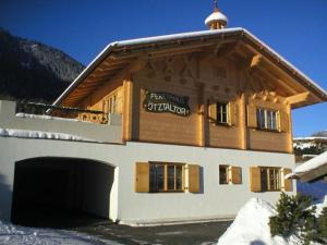 a large building with a garage in the snow at Ferienhaus Ötztaltor In Sautens in Sautens