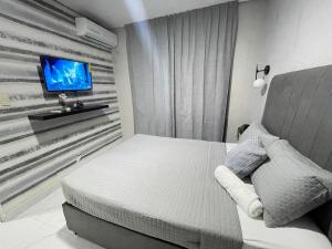 une chambre avec un lit et une télévision sur un mur dans l'établissement Cerca del aeropuerto los frailes I, à Los Frailes