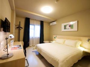 a bedroom with a large white bed and a desk at Jinjiang Inn Wenling Daxi in Wenling +34 photos