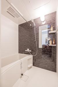 ein Badezimmer mit Dusche, Waschbecken und Spiegel in der Unterkunft Mi-HOTEL SHIMOKITAZAWA in Tokio + 221 Fotos