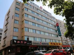 a large building with cars parked in front of it at Jinjiang Inn Yantai Wanda Plaza Huanshan Road in Yantai