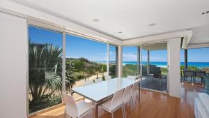 a dining room with a table and views of the ocean at The Pavillion 1 - Beachfront in Wamberal