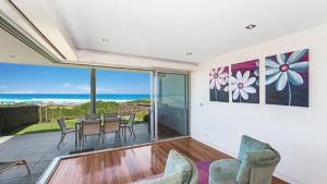 a dining room with a view of the ocean at The Pavillion 1 - Beachfront in Wamberal