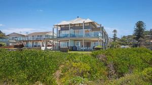 a large house sitting on top of a beach at The Pavillion 1 - Beachfront in Wamberal +8 photos