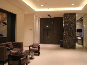 a lobby with a couch and chairs and a table at Jinjiang Inn Select Xining West Wusi Road New Hualian Square in Xining