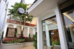 a store front with a tree and a window at Sira Boutique Chiang Mai in Chiang Mai