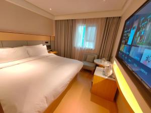 una camera d'albergo con un letto e una TV a schermo piatto di JI Hotel Shanghai Zhongshan Park Jiangsu Road (formerly Jiangsu Road Subway Station Branch) a Shanghai Altre 12 foto