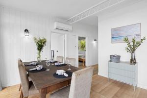 Un comedor con mesa y sillas de madera. en Horizon Views, en Lorne