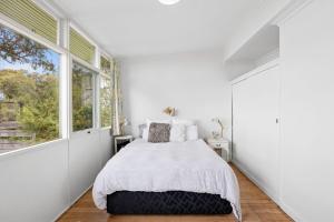 Un dormitorio blanco con una cama y una ventana grande. en Horizon Views, en Lorne