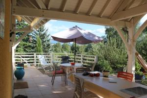 un patio con mesa y sombrilla en L'Etape, en Belley